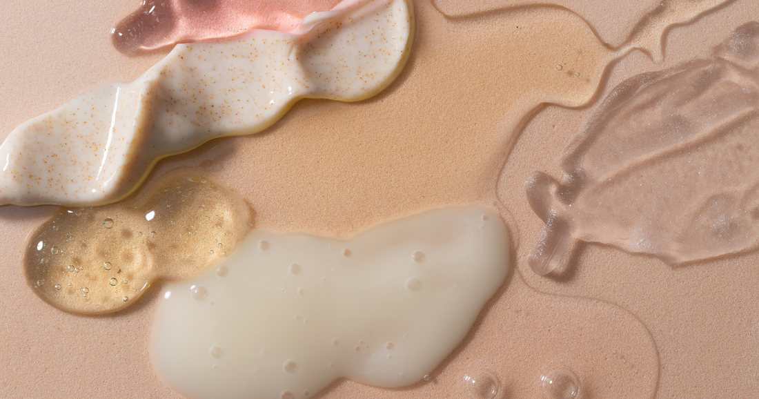 Flat lay of natural skincare product textures on a neutral background, showing creams, oils, and balms in soft, organic swatches.