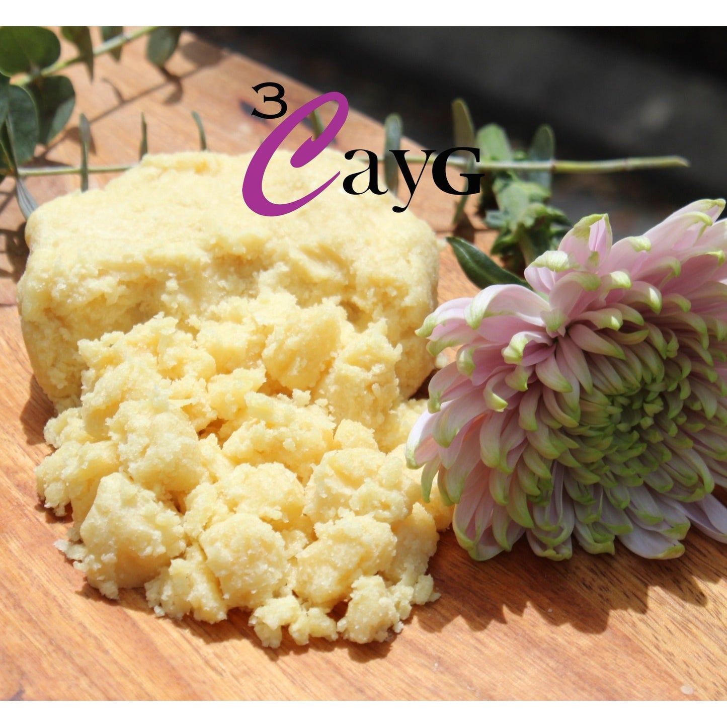 Murumuru butter on a wooden surface with a pink and green flower and '3 CayG' branding.