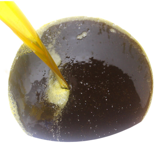 Neem oil being poured into a white container