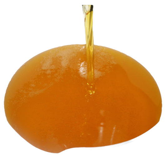 Baobab oil being poured into a bowl on a white background
