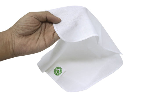 Hand holding a white muslin cloth with a green logo on a white background